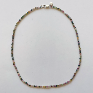 Beautiful, handcrafted 3mm round faceted Tourmaline semi-precious stone necklace; elegant on its own or with a pendant/charm, and perfect for layering; adorned with .925 sterling silver Jai Style hand-embossed charm and lobster clasp; 18" length.