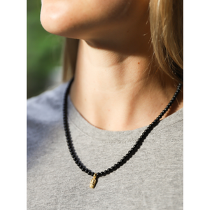 Beautiful gold vermeil Thai amulet on 18" necklace hand-beaded with 4mm matte black onyx semi-precious stones. Adorned with hand-pressed Jai Style charm and lobster clasp in .925 sterling silver and plated in 22K gold.