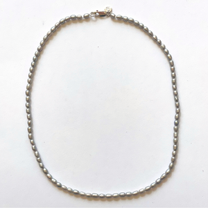 Beautiful handcrafted 16" necklace of organic freshwater 6mm grey rice pearls. Elegant on its own and perfect for layering. Adorned with .925 sterling silver Jai Style hand-embossed charm and lobster clasp.