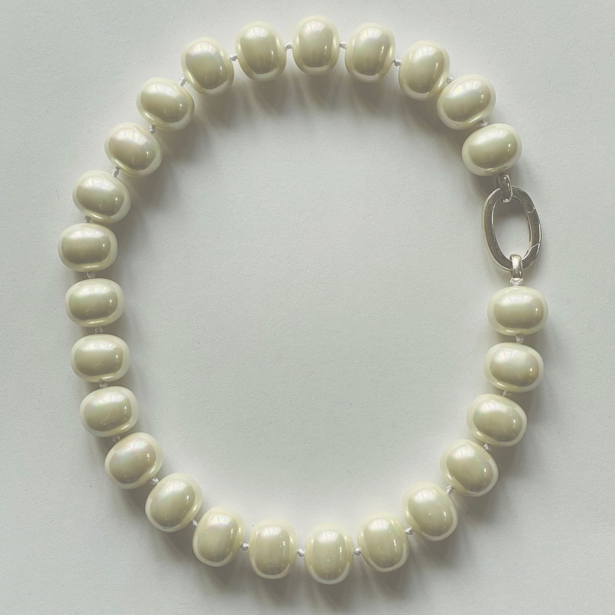 Beautiful handcrafted 18" statement necklace of organic freshwater white shell pearl, approx. 19 m x 11 mm. Elegant on its own and perfect with your favourite pendant. Adorned with .925 sterling silver oval clasp.