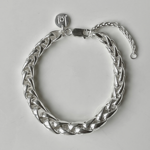 Hand-woven sterling silver bracelet is inspired by the intricate designs of the street tile art we discovered in Portugal. Woven entirely by hand in solid .925 sterling silver; a statement piece on its own yet perfect for layering. Chain has a graduated thickness from 5mm to 9mm; adorned with Jai Style embossed sterling silver charm and lobster claw clasp.