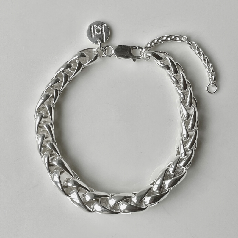 Hand-woven sterling silver bracelet is inspired by the intricate designs of the street tile art we discovered in Portugal. Woven entirely by hand in solid .925 sterling silver; a statement piece on its own yet perfect for layering. Chain has a graduated thickness from 5mm to 9mm; adorned with Jai Style embossed sterling silver charm and lobster claw clasp. Bracelet measures 17.6 cm (7 in.) and has a 5 cm (2 in.) extender.