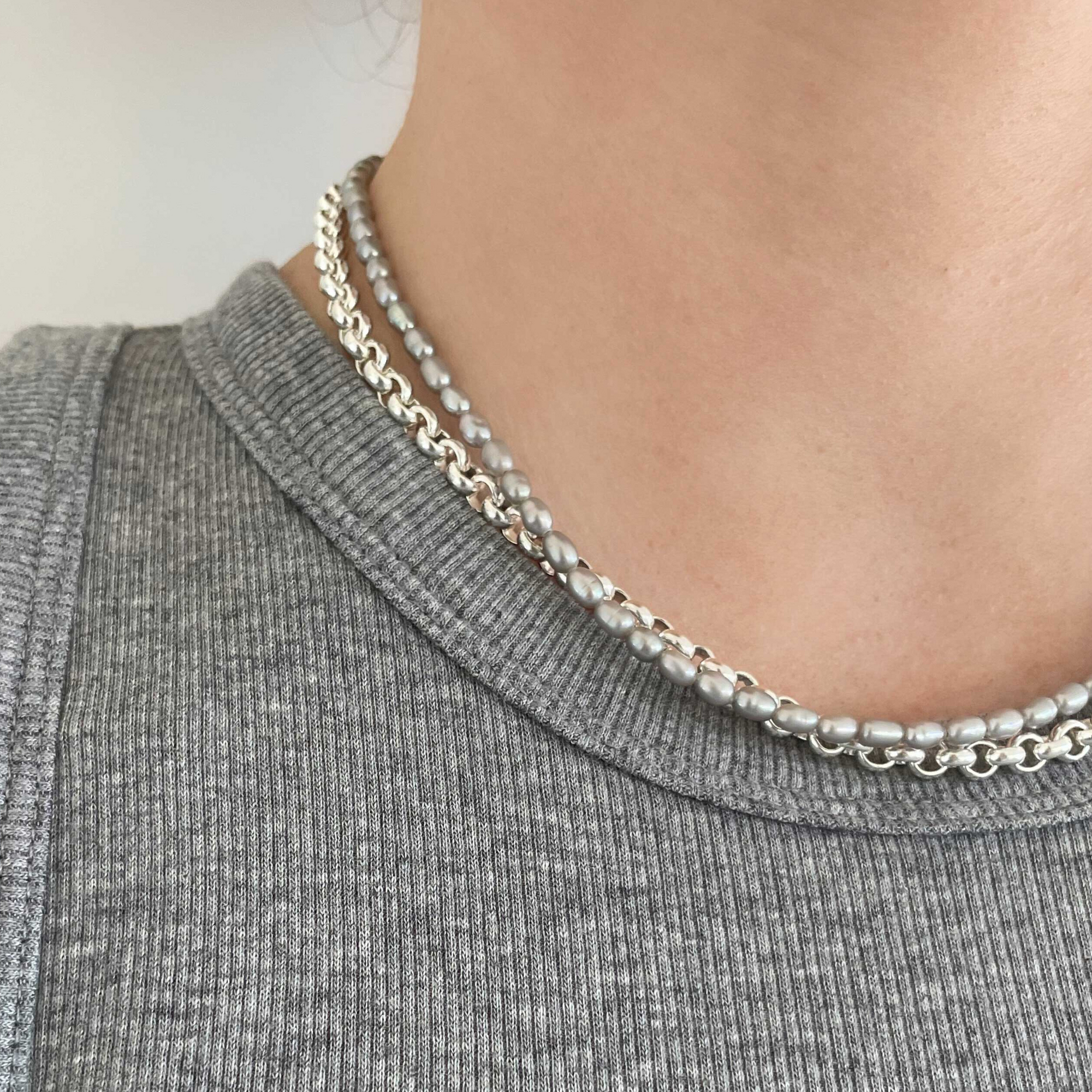 Beautiful handcrafted 18" necklace of organic freshwater 6mm grey rice pearls. Elegant on its own and perfect for layering. Adorned with .925 sterling silver Jai Style hand-embossed charm and lobster clasp.