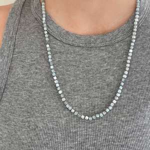 Beautiful, 4mm square cut faceted Aquamarine semi-precious stones are hand-knotted with silk thread and finished with a sterling silver Jai Style charm clasp; can be worn with clasp in the back or in the front with your favourite charm(s) or pendant; 24" length.