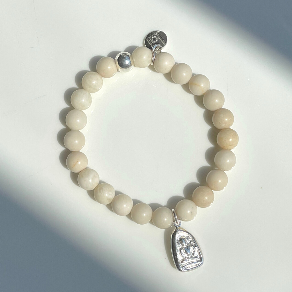 Beautiful 8mm cream river stone bead bracelet with hand cast .925 sterling silver Thai amulet, Jai Style charm, and ball bead. Stretch bracelet measures 18.4 cm