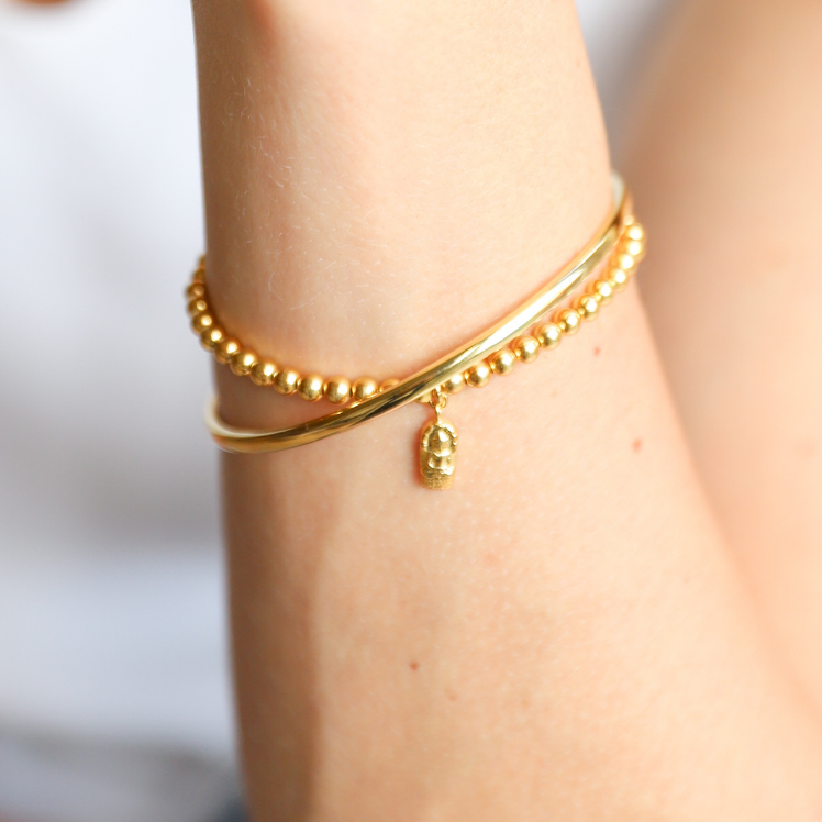 Beautiful gold vermeil 4mm ball bead bracelet. Adorned with gold vermeil amulet Amulet is hand-cast in .925 sterling silver and plated in 22K gold. Stretch bracelet measures 18.4 cm (7 1/4 in.).