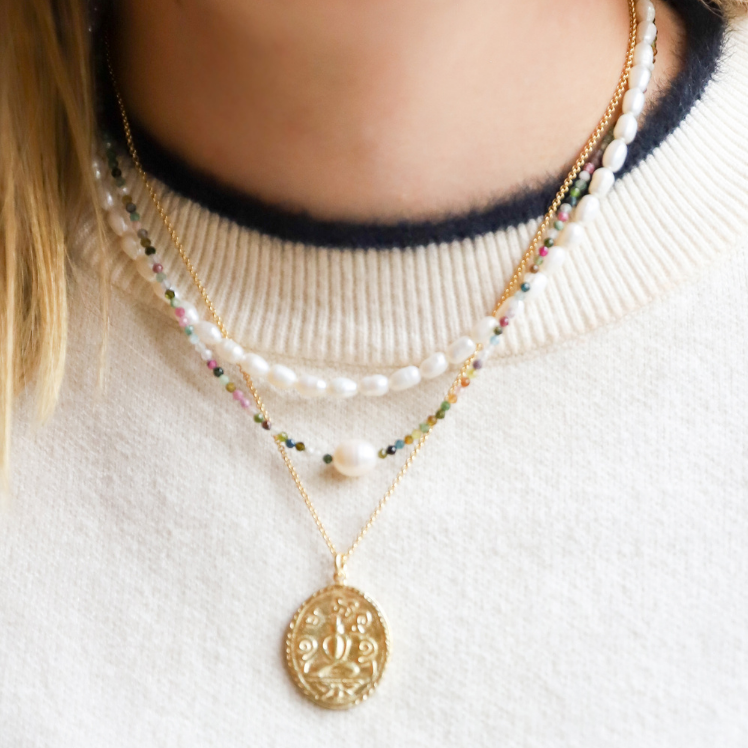 Beautiful, handcrafted 2mm Tourmaline semi-precious stone necklace features a single white organic freshwater potato pearl; elegant on its own and perfect for layering; adorned with 22K gold vermeil Jai Style hand-embossed charm, chain, and lobster clasp; available in two lengths: 16" necklace with 2" extender, and 18" necklace with 2" extender.