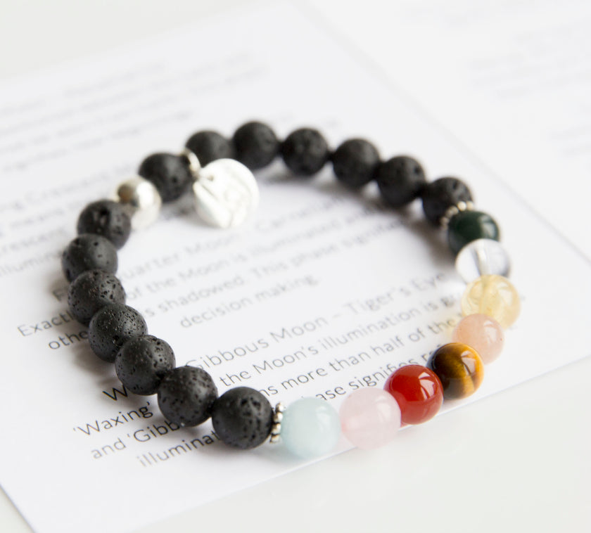 Beautiful lava stone bracelet is adorned with 8 unique semi-precious stones representing each phase of the Moon's cycle. Use your bracelet and essential oil to connect to the Moon's phases and harness its energy in your spiritual practice. Adorned with sterling silver ball bead and charm, stretch, measures 18.4 cm.